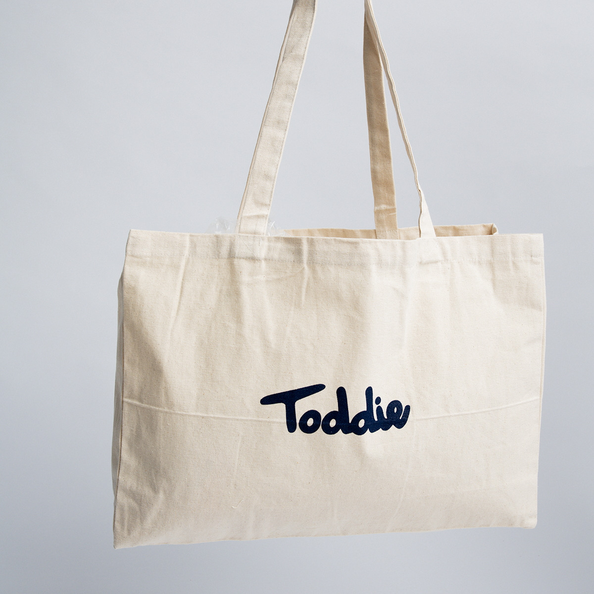 Canvas Bag made from durable cotton with bold Toddie logo, spacious and sustainable for everyday use by Toddie.