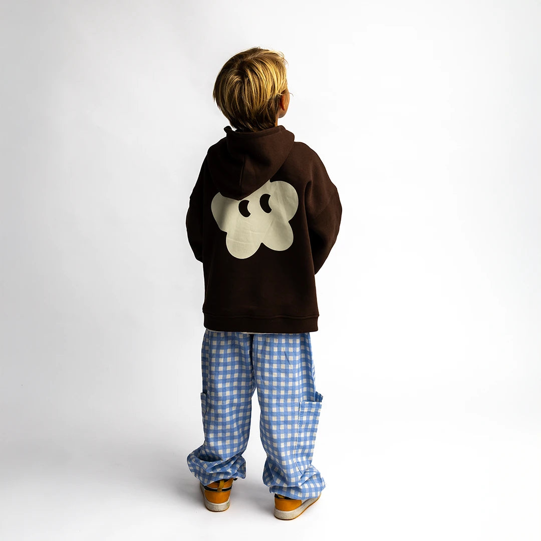 Toddie - Oversized Hoodie in brown with signature flower on back, worn by child in blue checkered pants.