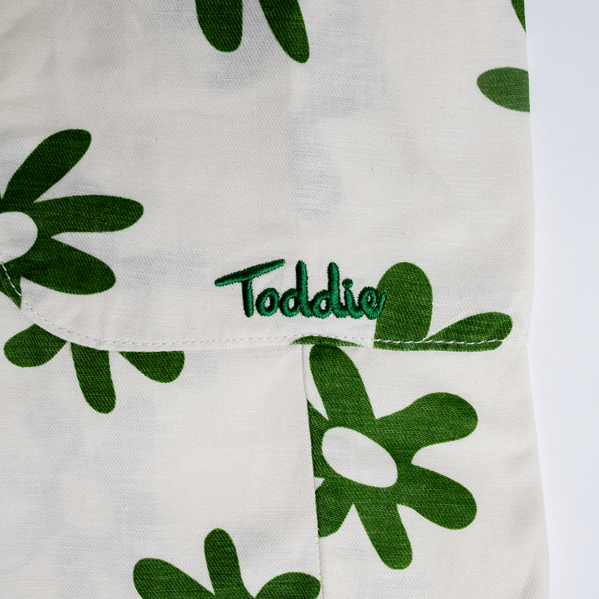 Close-up of green flower print and pocket detail on Cargo Flower Pants made from premium cotton for kids.