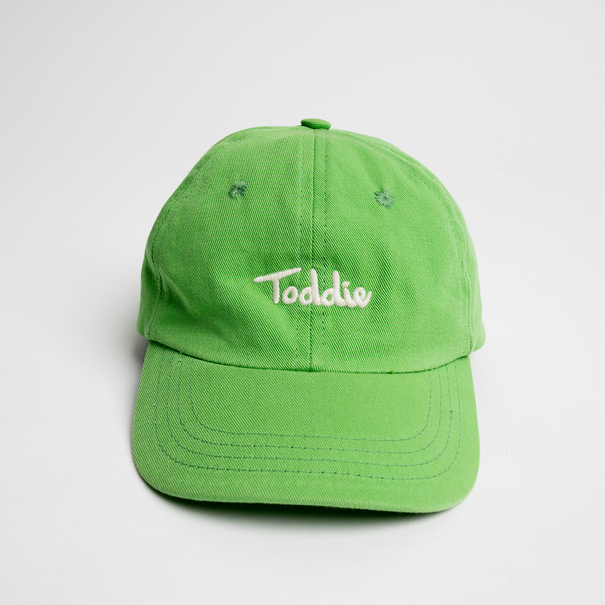 Green Toddie Cap with embroidered logo, designed for comfort, durability, and a vibrant pop of color.