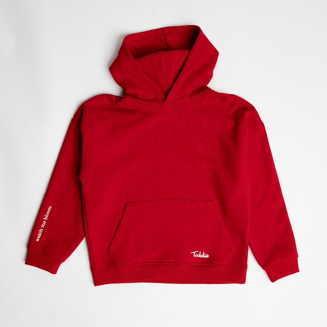 WMB - Oversized Hoodie Red in premium cotton with double-layered hood and “Watch Me Bloom” sleeve slogan for kids.