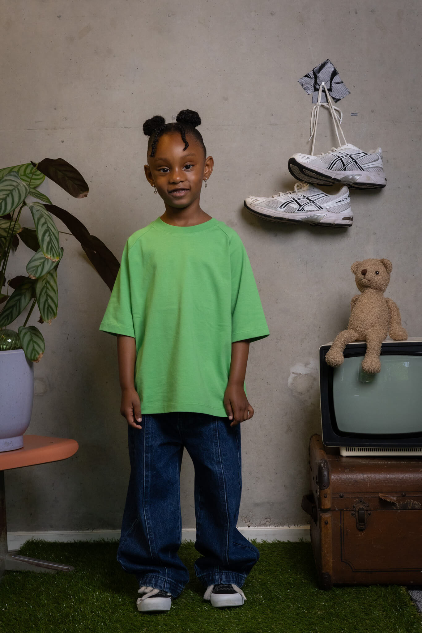 Confident kid rocking FIT #8 oversized green tee and jeans, proving real style is Toddie’s creative game.