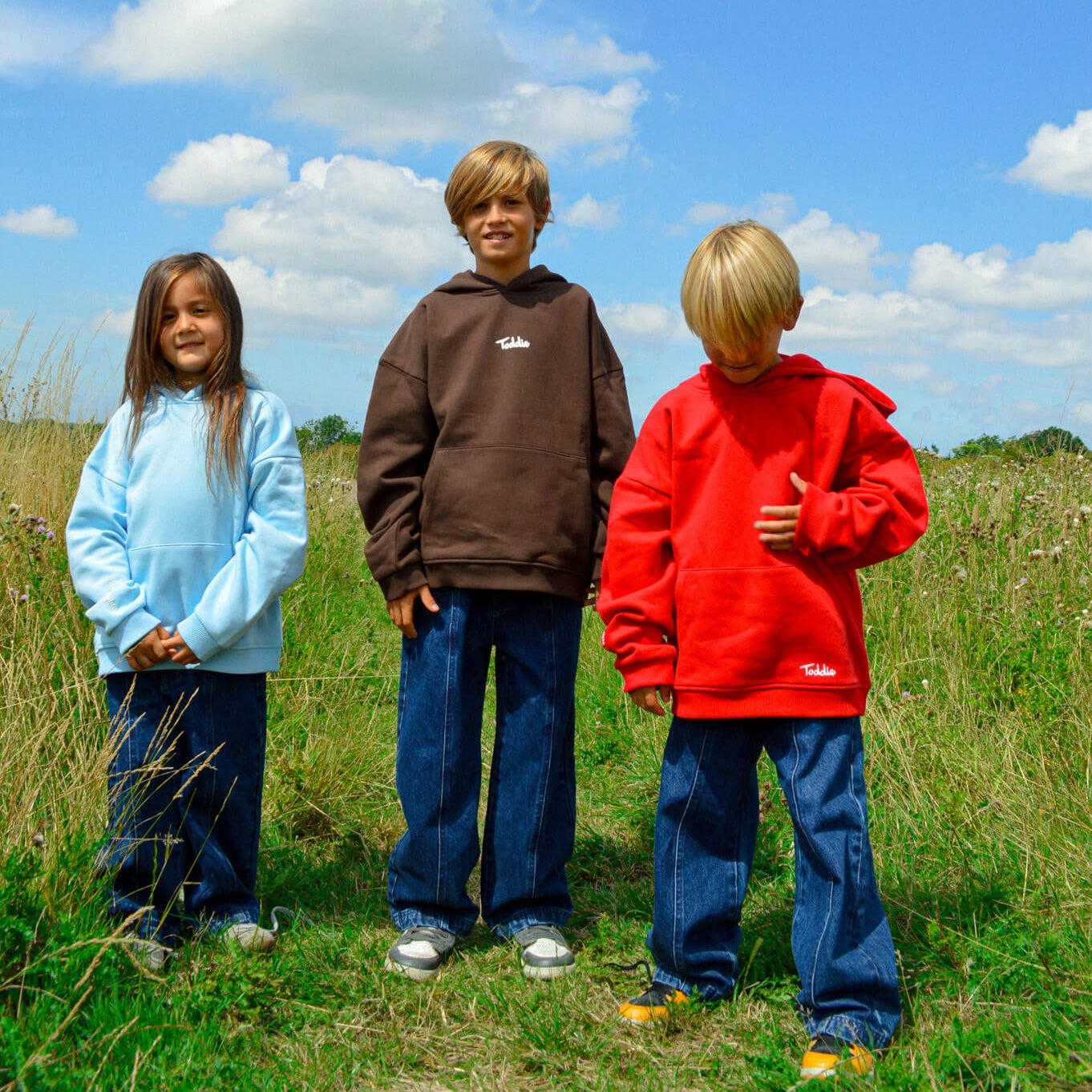 Three kids outdoors wearing cozy oversized hoodies including WMB - Oversized Hoodie Blue by Toddie