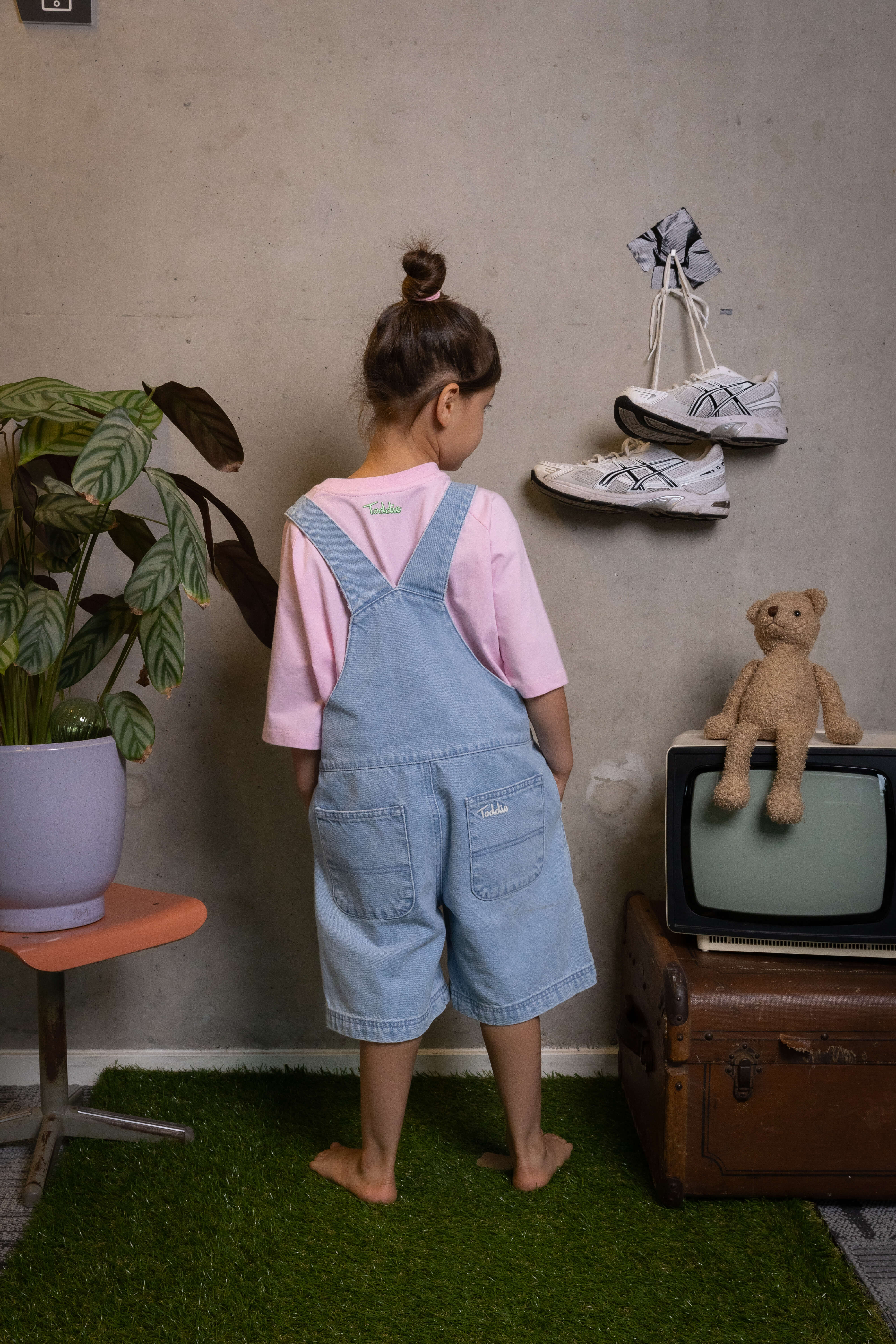 Toddler rocking relaxed-fit denim dungarees and a soft pink tee back view, ready for adventure – FIT #13 by Toddie