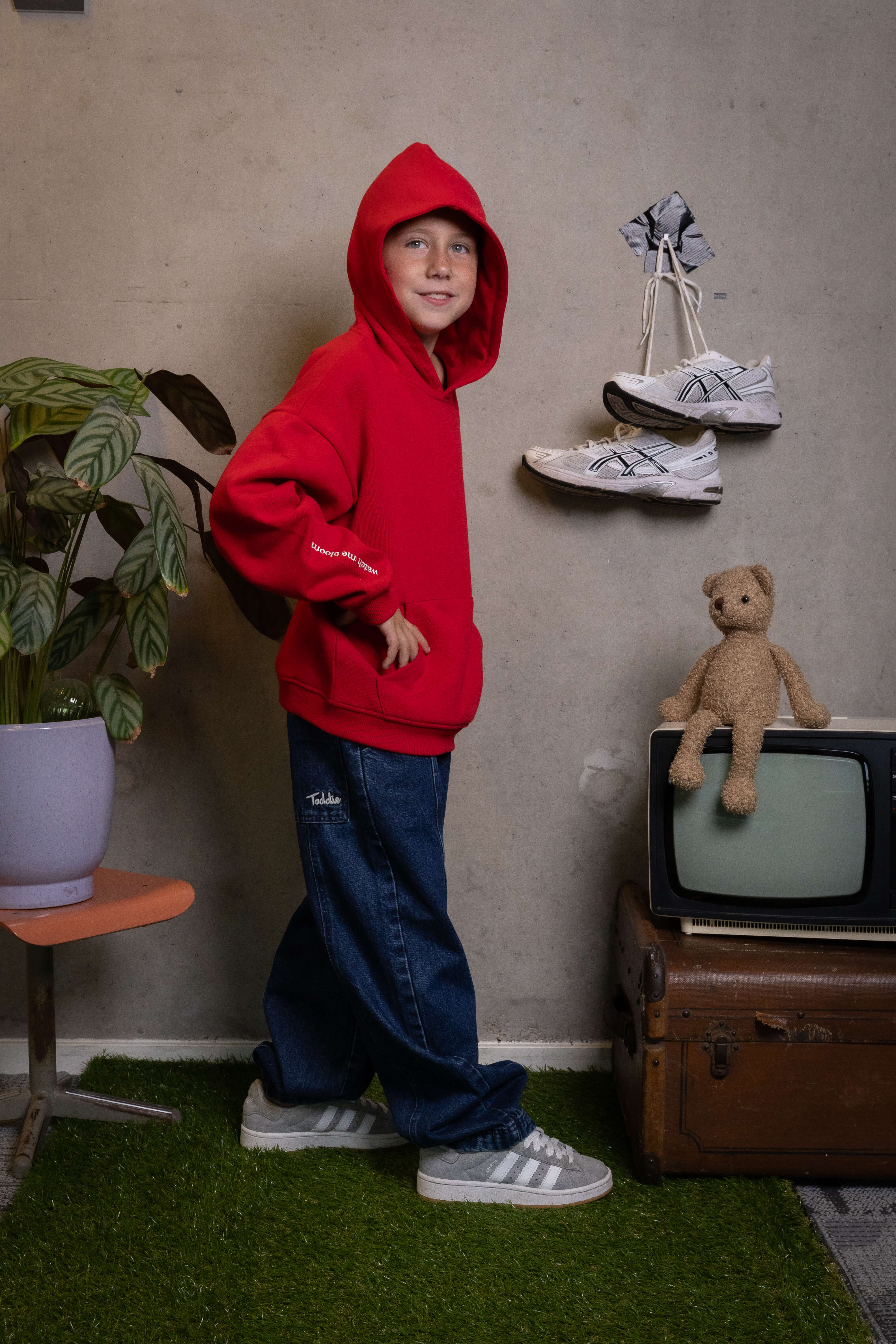 Kid rocking FIT #14’s balloon jeans and bold red hoodie—comfort and style that scream “Watch Me Bloom.” Toddie