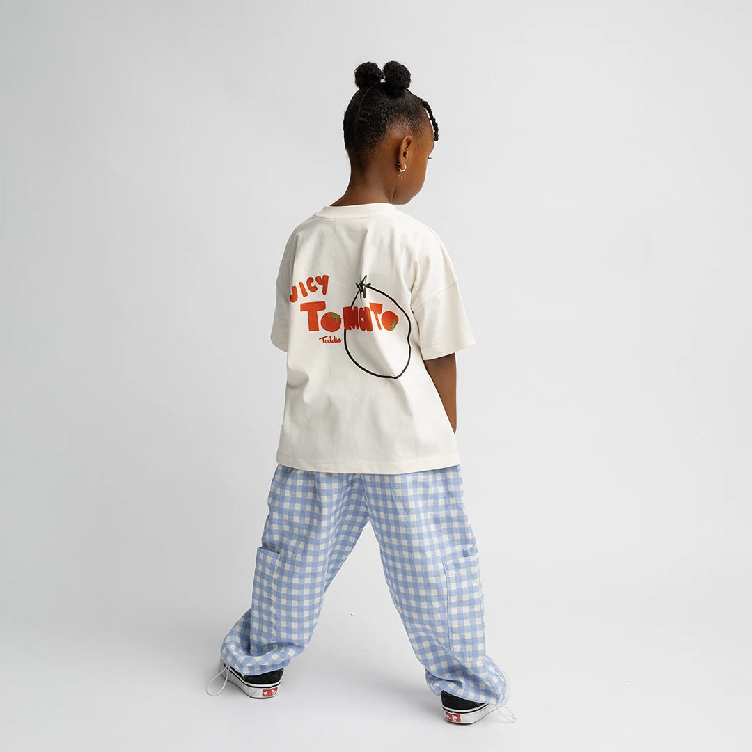 Child wearing Juicy Tomato - Oversized Tee with bold tomato graphic on back in relaxed fit and soft cotton fabric.