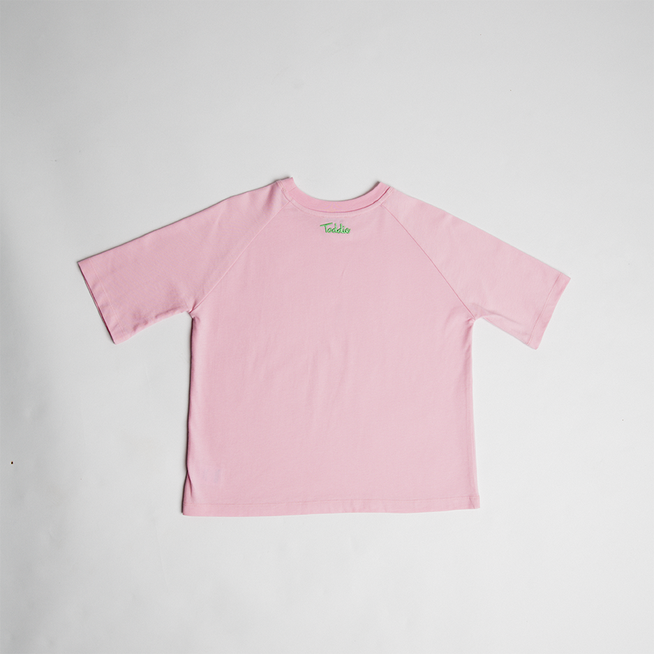 Oversized Tee in soft pink cotton with subtle Toddie embroidery on the back, designed for comfort and everyday wear.